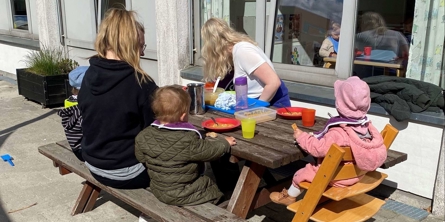 Børn og voksne spiser udendørs