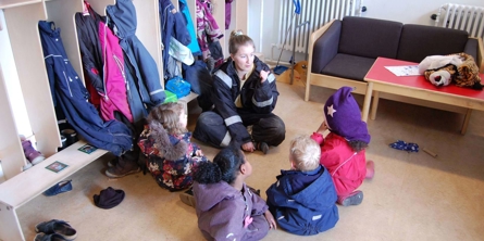 Børn snakker med voksen i garderobe